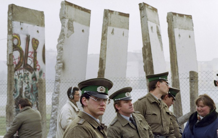 In this Nov. 13, 1989, file photo, East German border guards stand in front of segments of the Berlin Wall, which were removed to open the wall at Potsdamer Platz passage in Berlin.