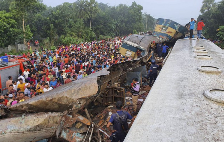 People gather near badly damages coaches after two speeding trains collided in in Brahmanbaria district, 82 kilometers (51 miles) east of the capital, Dhaka, Bangladesh, Tuesday, Nov.12, 2019