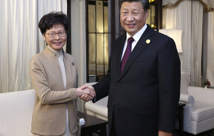 In this Nov. 4, 2019, file photo released by China's Xinhua News Agency, Chinese President Xi Jinping, right, poses with Hong Kong Chief Executive Carrie Lam for a photo during a meeting in S