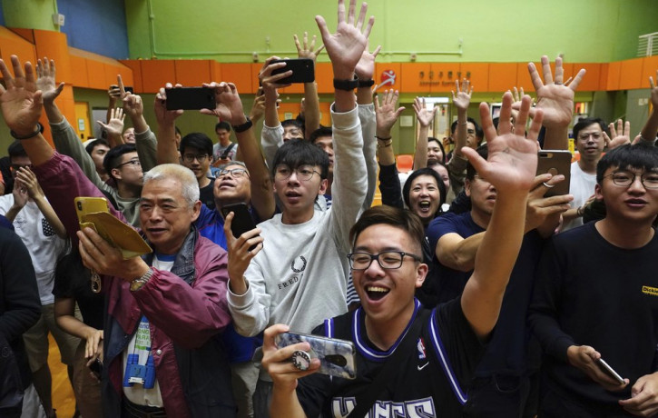 Supporters of pro-democracy candidate Angus Wong celebrate after he won in district council elections in Hong Kong, early Monday, Nov. 25, 2019.