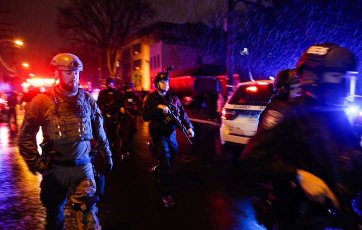 Law enforcement personnel walk near the scene following a shooting, Tuesday, Dec. 10, 2019, in Jersey City, N.J.