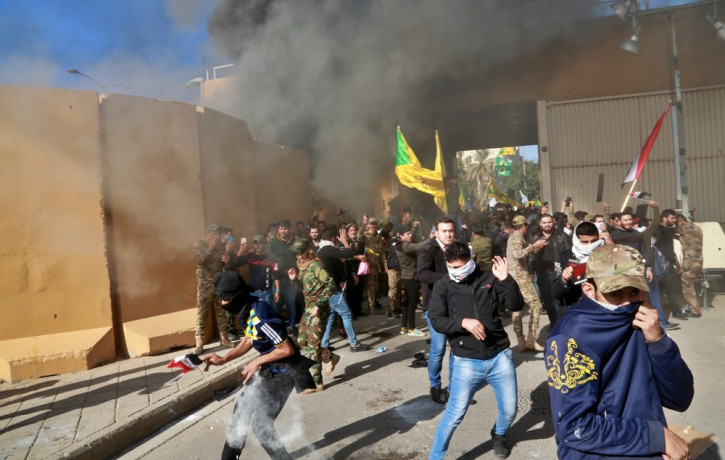 US soldiers fire tear gas towards protesters who broke into the U.S. embassy compound, in Baghdad, Iraq, Tuesday, Dec. 31, 2019.