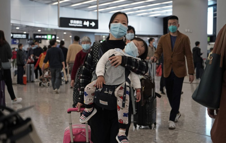 Passengers wearing protective face masks enter the departure hall of a high speed train station in Hong Kong, Thursday, Jan. 23, 2020.