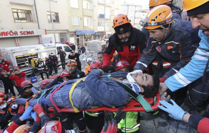 Rescue workers carry a wounded man that was found alive in the rubble of a building destroyed on Friday's earthquake in Elazig, eastern Turkey, Saturday, Jan. 25, 2020.
