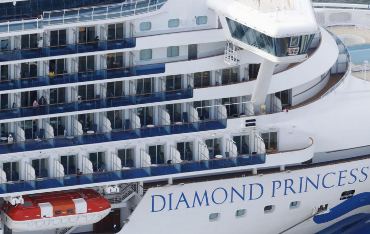 Some passengers are seen on the Diamond Princess as the cruise ship is anchored at Yokohama Port for supplies replenished in Yokohama, south of Tokyo, Thursday, Feb. 6, 2020.