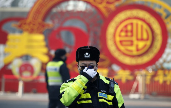 A traffic policeman adjusts his mask on a street in Beijing, Sunday, Feb. 9, 2020.