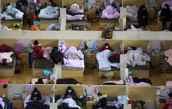 In this Monday, Feb. 17, 2020, photo released by Xinhua News Agency, patients infected with the coronavirus take rest at a temporary hospital converted from Wuhan Sports Center in Wuhan in ce