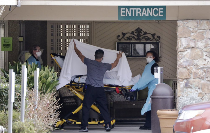A person is taken by stretcher to a waiting ambulance from a nursing facility where more than 50 people are sick and being tested for the COVID-19 virus, Saturday, Feb. 29, 2020, in Kirkland,