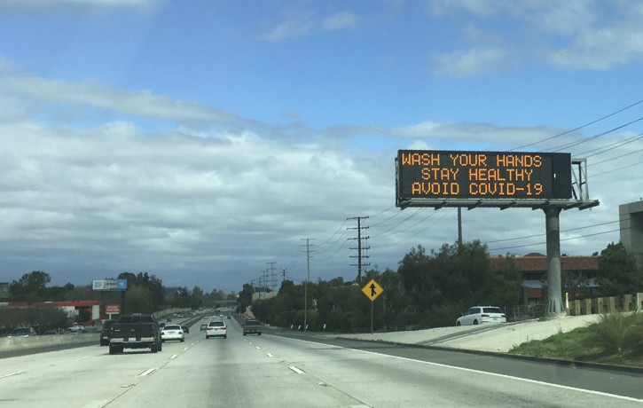 A Caltrans freeway sign reads: "Wash your hands, Stay healthy, Avoid COVID-19" in the San Fernando Valley section of Los Angeles.