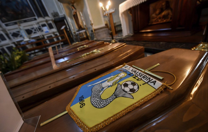Coffins, one of them with the pennant of the local soccer team, wait to be transported to cemetery, in the church of Serina, near Bergamo, Northern Italy, Saturday, March 21, 2020.