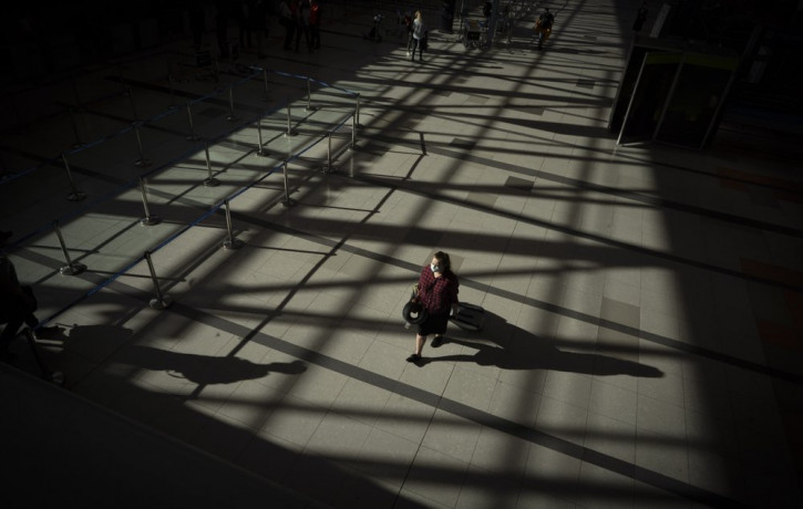 A passenger walks through an empty terminal at Ezeiza International Airport in Buenos Aires, Argentina, Monday, March 23, 2020. Most flights have been canceled to help stop the spread of the 
