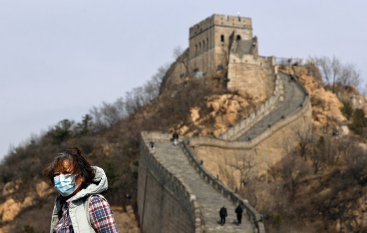 A woman wearing a protective face mask visits the Badaling Great Wall of China after it reopened for business following the new coronavirus outbreak in Beijing, China, Tuesday, March 24, 2020