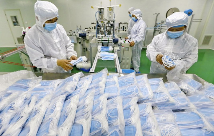 In this Feb. 7, 2020 file photo, workers pack surgical masks at a factory in Suining city in southwest China's Sichuan province.