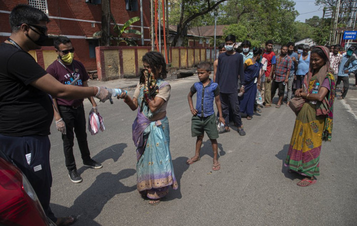 A group of Indians distribute free food and water to homeless people during a nationwide lockdown to curb the spread of new coronavirus in Gauhati, India, Sunday, April 19, 2020.