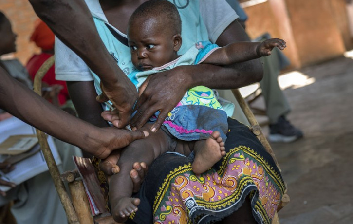 In this photo taken Wednesday, Dec. 11, 2019, health officials vaccine residents of the Malawi village of Tomali, where young children become test subjects for the world's first vaccine again