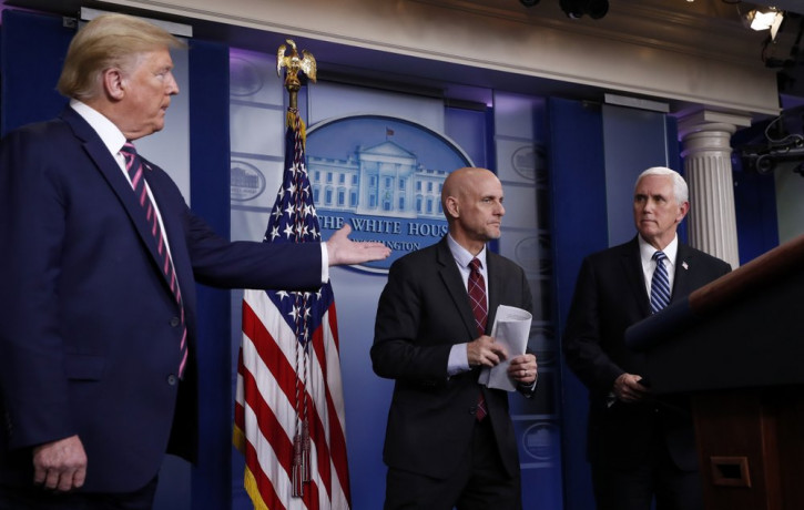 President Donald Trump gestures to Vice President Mike Pence as Stephen Hahn, commissioner of the U.S. Food and Drug Administration, steps back to the podium to answer a question during a bri