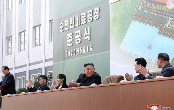 In this Friday, May 1, 2020, photo provided by the North Korean government, North Korean leader Kim Jong Un, center, claps during a ceremony at a fertilizer factory in South Pyongan, near Pyo