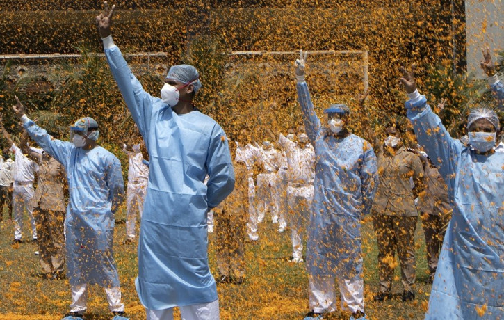 An Indian Air Force helicopter showers flower petals on the staff of INS Asvini hospital in Mumbai, India, Sunday, May 3, 2020.