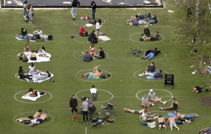 People relax in marked circles for proper social distancing at Domino Park in the Williamsburg neighborhood of Brooklyn during the current coronavirus outbreak, Sunday, May 17, 2020, in New Y