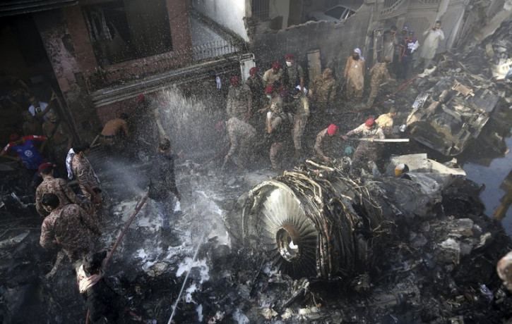 Volunteers look for survivors of a plane that crashed in residential area of Karachi, Pakistan, May 22, 2020.