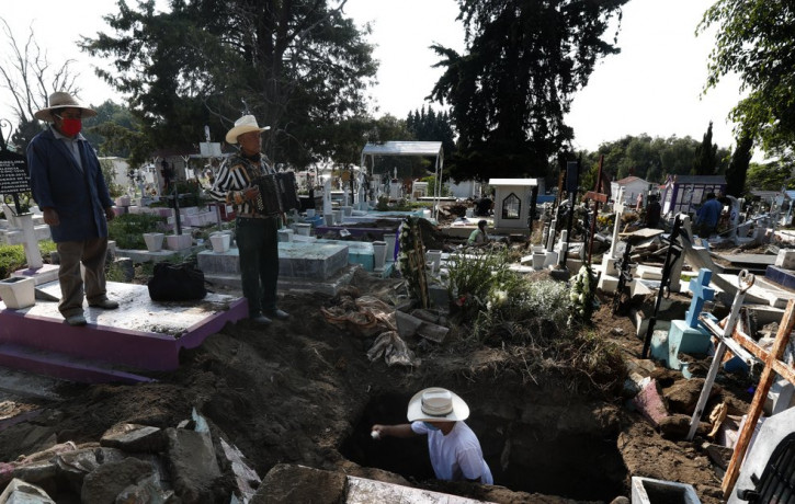 Cemetery musician Victor Dzib Cima, 70, plays his accordion as he waits for clients while cemetery workers remove coffins from gravesites that belonged to families who stopped paying rent at 