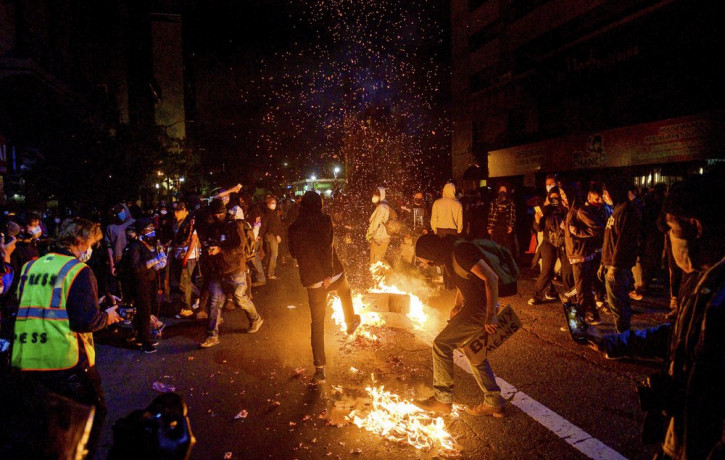 Demonstrators burn garbage in Oakland, Calif., on Friday, May 29, 2020, while protesting the Monday death of George Floyd, a handcuffed black man in police custody in Minneapolis.
