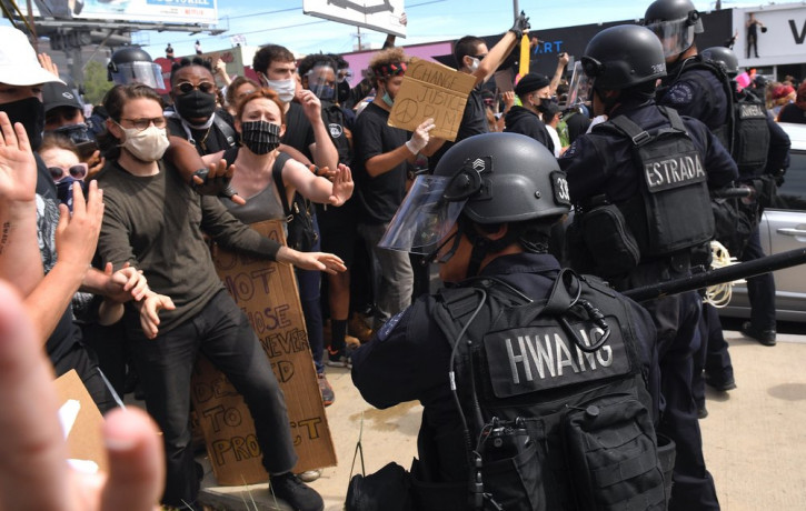 A Los Angeles police officer threatens protesters during a protest over the death of George Floyd Saturday, May 30, 2020, in Los Angeles.