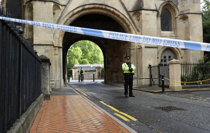 Police stand guard at the Abbey gateway of Forbury Gardens park in Reading town centre following Saturday's stabbing attack in the gardens, Sunday June 21, 2020.