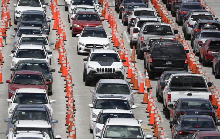 Lines of cars wait at a coronavirus testing site outside of Hard Rock Stadium, Friday, June 26, 2020, in Miami Gardens, Florida.