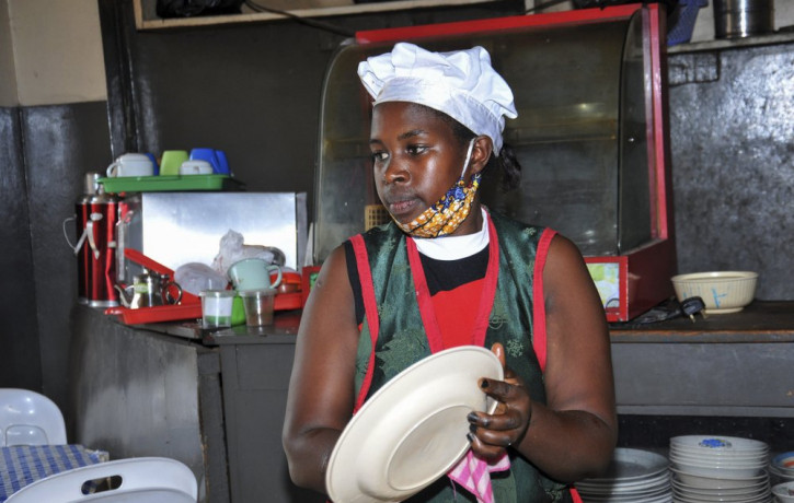 In this photo taken Saturday, June 20, 2020, Rebecca Nakamanya works at a restaurant near a bus terminal in capital Kampala, Uganda.