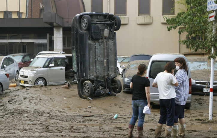 A car stands vertically on a muddy road after being washed away by flood, in Hitoyoshi, Kumamoto prefecture, southwestern Japan, Sunday, July 5, 2020.