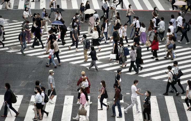 People wearing a protective face mask to help curb the spread of the coronavirus walk at Shibuya pedestrian crossing Thursday, July 9, 2020, in Tokyo.