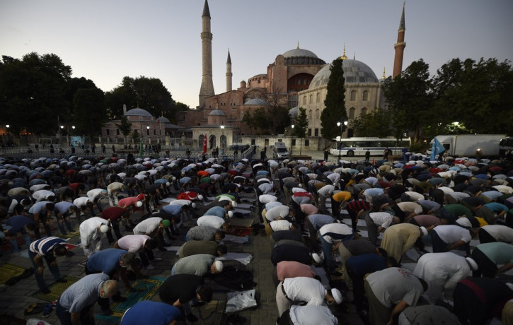 Muslims offer their evening prayers outside the Byzantine-era Hagia Sophia, one of Istanbul's main tourist attractions in the historic Sultanahmet district of Istanbul, following Turkey's Cou