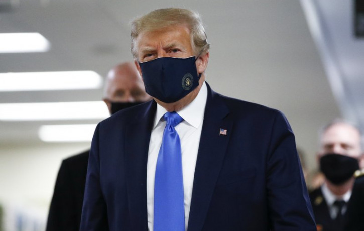 US President Donald Trump wears a mask as he walks down the hallway during his visit to Walter Reed National Military Medical Center in Bethesda, Md., Saturday, July 11, 2020.