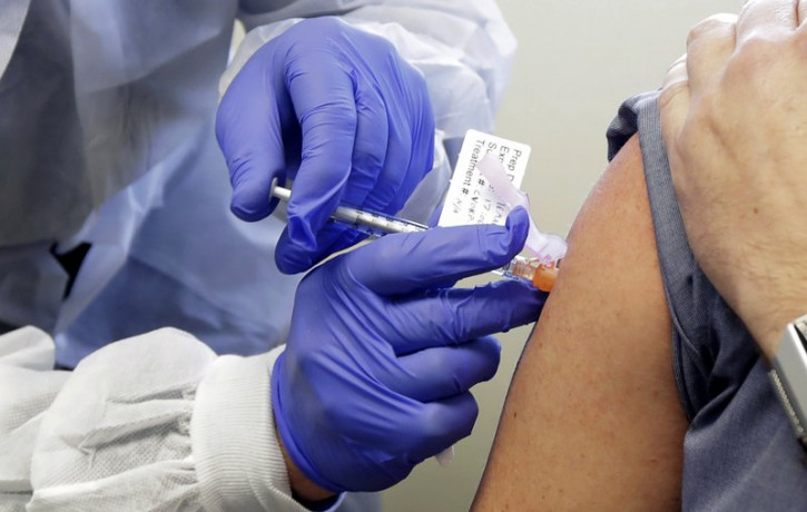 In this March 16, 2020, file photo, a subject receives a shot in the first-stage safety study clinical trial of a potential vaccine by Moderna for COVID-19 at the Kaiser Permanente Washington