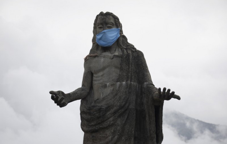 A protective face mask adorns a Jesus Christ statue as a reminder for residents to wear masks as a precaution against the spread of the new coronavirus, in the Petare neighborhod in Caracas, 