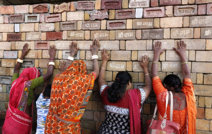 In this Nov. 11, 2019 file photo, Hindu women devotees pray to the bricks reading "Shree Ram" ( Lord Ram), which are expected to be used in constructing Ram temple, in Ayodhya, India.