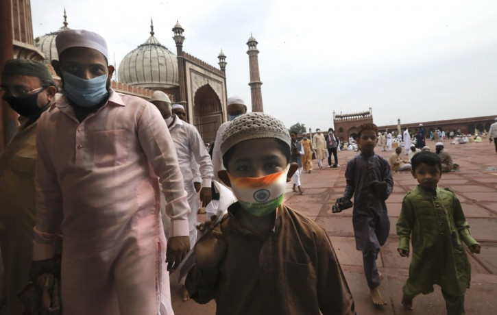 An Indian Muslim boy wears a protective mask in the colors of the Indian national flag, leaves after offering Eid al-Adha prayer at the Jama Masjid in New Delhi, India, Saturday, Aug.1, 2020.