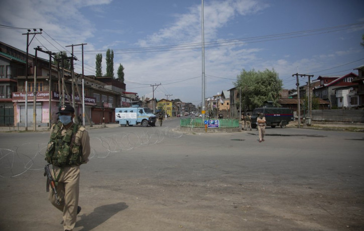 Policemen and paramilitary soldiers patrol a road during curfew in Srinagar, Indian controlled Kashmir, Tuesday, Aug. 4, 2020.