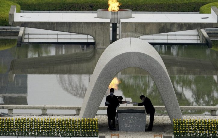 Kazumi Matsui, right, mayor of Hiroshima, and the family of the deceased bow before they place the victims list of the Atomic Bomb at Hiroshima Memorial Cenotaph.