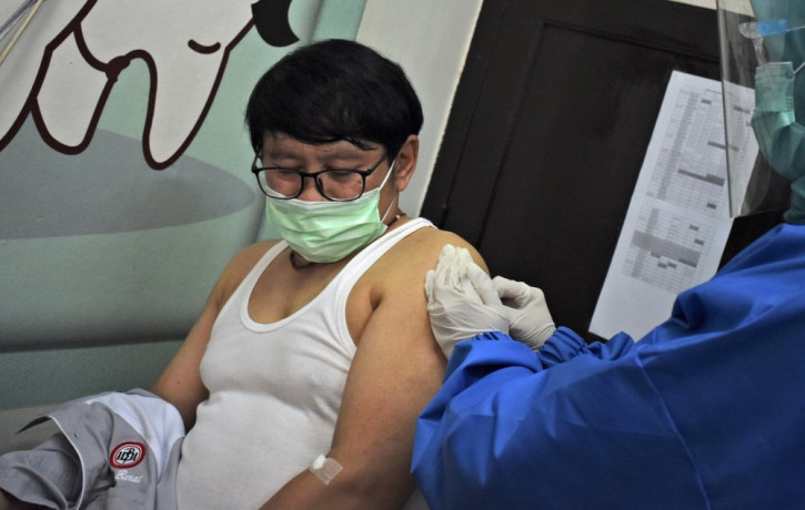 A medical worker gives coronavirus vaccine candidate to a volunteer during a trial at a community health center in Bandung, West Java, Indonesia, Friday, Aug. 14, 2020.