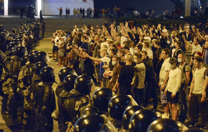 In this file photo taken on Sunday, Aug. 9, 2020, people argue with police during a rally after the Belarusian presidential election in Minsk, Belarus.