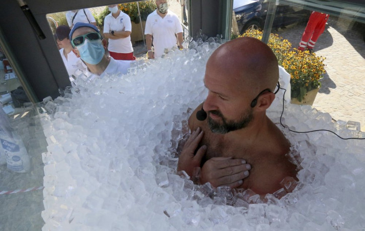Austrian ice swimmer Josef Koeberl is standing in a glass cabin filled with ice try to break the world record for a human to stay side an ice box in Melk, Saturday, Sept. 5, 2020.