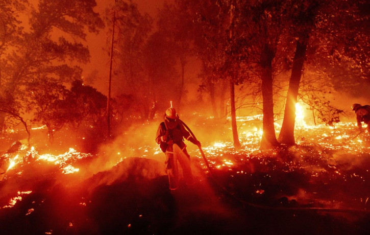 A firefighter battles the Creek Fire as it threatens homes in the Cascadel Woods neighborhood of Madera County, Calif., on Monday, Sept. 7, 2020.