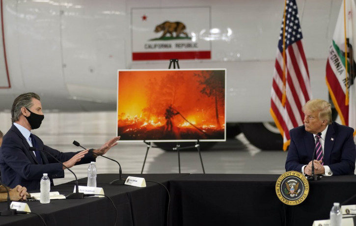 President Donald Trump listens as California Gov. Gavin Newsom speaks during a briefing at Sacramento McClellan Airport, in McClellan Park, Calif., Monday, Sept. 14, 2020, on the western wild