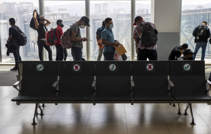 Passengers wait to board a humanitarian flight to Canada at the La Aurora international airport in Guatemala City, Thursday, Sept. 17, 2020.