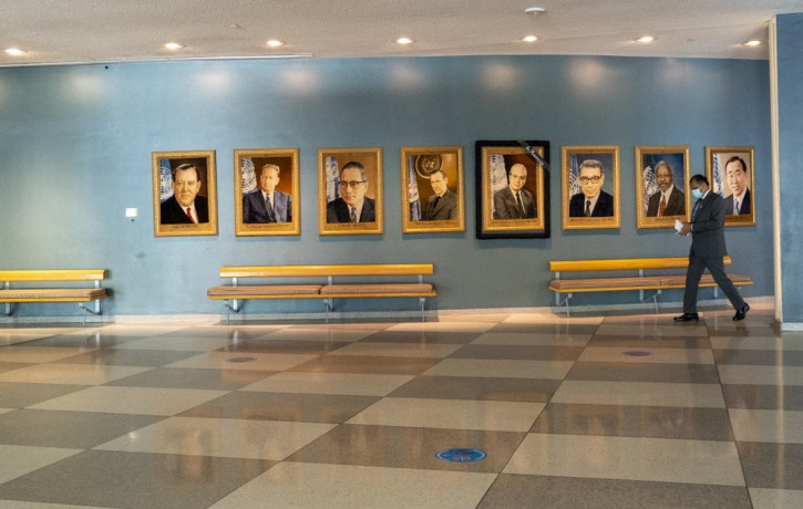 A man walk past portraits of former United Nations Secretary-Generals, Monday, Sept. 21, 2020 at United Nations headquarters.
