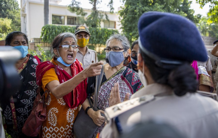 An Indian activist argues with a police officer before being detained by police during a protest in New Delhi, India, Wednesday, Sept. 30, 2020.