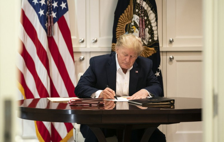In this image released by the White House, President Donald Trump works in the Presidential Suite at Walter Reed National Military Medical Center in Bethesda, Md. Saturday, Oct. 3, 2020, afte