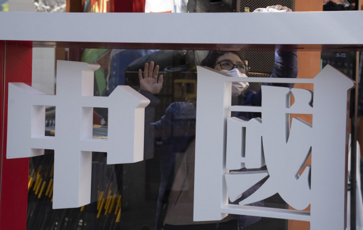A worker cleans the panel with the words "China" written on it during a Chinese sporting goods brand promotion event in Beijing on Sunday, Oct. 4, 2020.